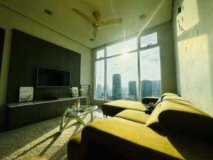 a living room with two beds and a large window at Soho Suites KLCC Kuala Lumpur in Kuala Lumpur