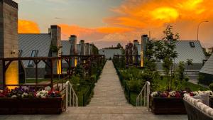 a garden with flowers and a sunset in the background at In The Garden Ilıca Thermal Resort Hotel & Aqua Park in Erzurum