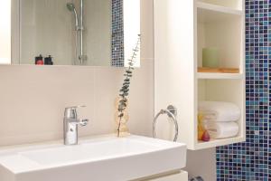 a bathroom with a white sink and a mirror at Ying'nFlo, Wesley Admiralty, Hong Kong in Hong Kong