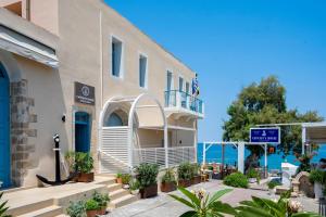 budynek ze schodami i roślinami nad oceanem w obiekcie Captain's House Hotel Suites & Apartments w mieście Panormos