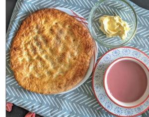 a pie sitting on a plate next to a bowl of butter at Taj Mahal Residency Muzaffarabad in Muzaffarabad