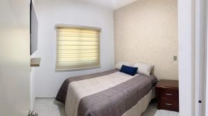 - une chambre avec un lit doté d'un oreiller bleu dans l'établissement Departamento Cardones - 5 Min Zona Dorada - 6 Personas Alberca Compartida, à Mazatlán