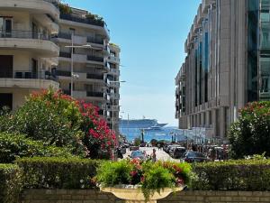 a city street with buildings and flowers and the ocean at Lavande de Croisette in Cannes