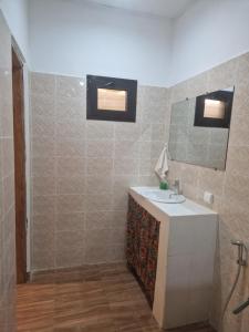 La salle de bains est pourvue d'un lavabo et d'un miroir. dans l'établissement La Cazasamba, à Cap Skirring