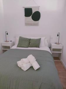 a bed with two towels on top of it at San Centro Airport IFEMA Wizink Metropolitano Apartments in Madrid