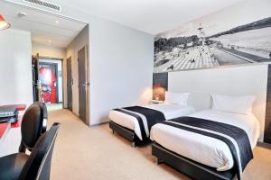 Postel nebo postele na pokoji v ubytování Hôtel des Lumières Lyon Meyzieu Arena Stadium