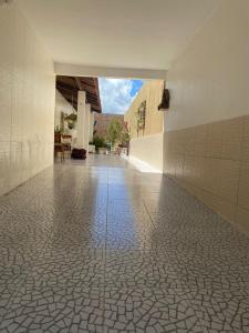pusty korytarz z podłogą wyłożoną kafelkami w budynku w obiekcie CASA DE TEMPORADA MEL w mieście Piranhas