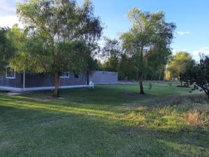 a yard with two trees and a building at Finca La Chiqueta in Albardón