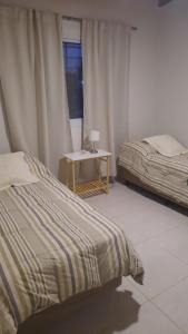 - une chambre avec 2 lits, une table et une fenêtre dans l'établissement Finca La Chiqueta, à Albardón
