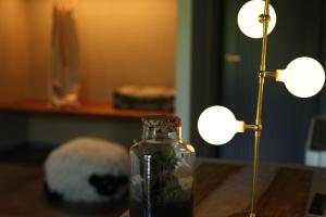 a glass jar on a table next to two lights at Tenuta Pezzapane in Alvignanello