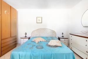 1 dormitorio con 1 cama azul y 2 almohadas en Villa Mara en Specchiolla 