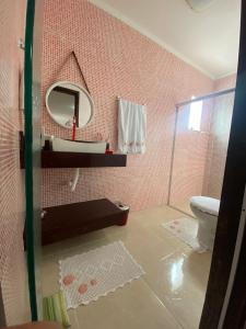 W łazience znajduje się lustro, umywalka i toaleta. w obiekcie CASA DE TEMPORADA MEL w mieście Piranhas