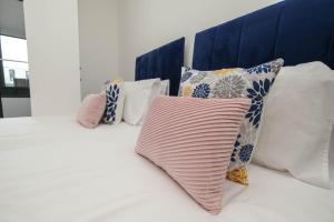 - un ensemble d'oreillers assis au-dessus d'un lit dans l'établissement Brand New 2 bedroom apartment Centre of Solihull, à Solihull