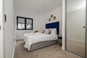 a white bedroom with a bed and a mirror at Brand New 2 bedroom apartment Centre of Solihull in Solihull