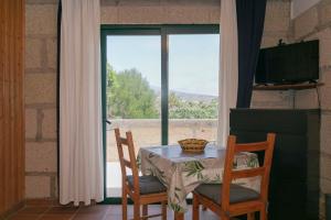 a table and two chairs with a table and a window at Casa Killa in Granadilla de Abona