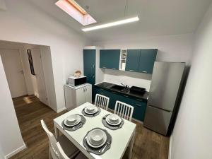 a small kitchen with a white table and a refrigerator at XOX Villa House & Garden Bucharest in Bucharest