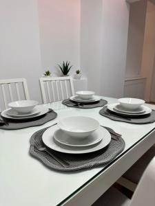 a table with plates and bowls on top of it at XOX Villa House & Garden Bucharest in Bucharest