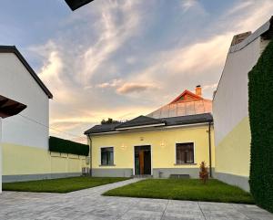 a yellow and white house with a yard at XOX Villa House & Garden Bucharest in Bucharest