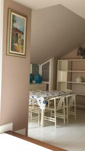 een kamer met een tafel en stoelen en een schilderij bij Villa Belvedere in Ospedaletti