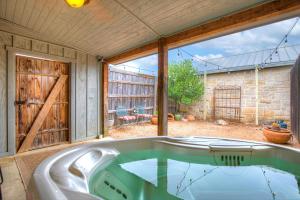 eine Badewanne in einem Zimmer mit einem großen Fenster in der Unterkunft Romantic Oasis with Hot Tub Near Fred and Wineries! in Fredericksburg