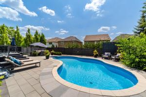 a swimming pool in a yard with chairs and a house at Poolside Perfection, Culinary Delight in Mississauga