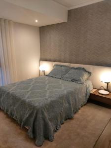 sypialnia z dużym łóżkiem i 2 lampami w obiekcie Stunning 2 Bedroom garage & balcony w Lizbonie