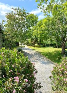 eine Schotterstraße in einem Park mit Bäumen und Blumen in der Unterkunft Maison Castaings in Lucq-de-Béarn