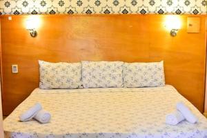a bed with two pillows and two towels on it at Palmas Park Hotel y Restaurant in Obligado