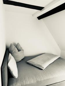 a bed in a white room with two pillows at Ochsen-Durlach in Karlsruhe
