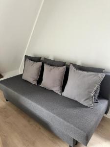 eine graue Couch mit vier Kissen darüber in der Unterkunft Ochsen-Durlach in Karlsruhe