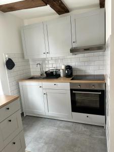 a kitchen with white cabinets and a black oven at Ochsen-Durlach in Karlsruhe