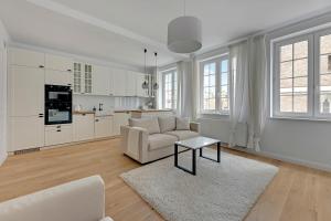 a white living room with a couch and a table at WAVE APARTMENTS WHITE PEARL IN GDANSK in Gdańsk