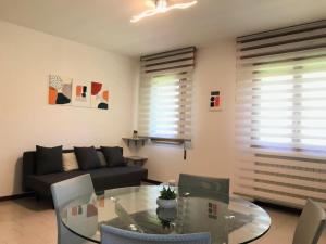 Una sala de estar con una mesa de cristal y un sofá. en Casa Céline, en Mestre