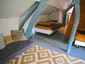 1 Schlafzimmer mit 2 Etagenbetten und einem Sofa in der Unterkunft Belle Longère normande, cheminée et jardin arboré in Canville-les-Deux-Églises