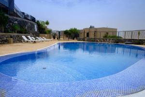 una gran piscina de agua azul en un edificio en Villa Del Mar La Tagora costa Adeje panoramic, en Adeje