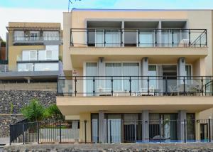 un edificio con un balcón con sillas. en Villa Del Mar La Tagora costa Adeje panoramic, en Adeje
