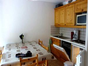 eine kleine Küche mit einem Tisch und Stühlen in der Unterkunft Appartement Avec Balcon in Vars