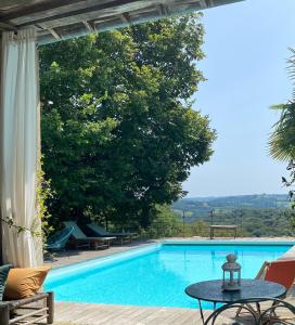a swimming pool with a table in front of it at Maison Castaings in Lucq-de-Béarn