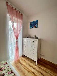 a bedroom with a dresser and a window at Apartmán Roda2 Malé Lipno in Černá v Pošumaví