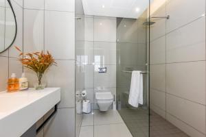 e bagno con servizi igienici e doccia in vetro. di Chic Apartment in 5 star hotel a Johannesburg