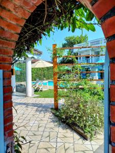 a brick archway leading to a pool with a table at Pousada Eldorado Guarujá o o o o o o o o o o o o o o o o o o o o o o o o o o o o o o o o o o o o o o o o o o o o o o o o o o o o o o o o o o o o o o o in Guarujá