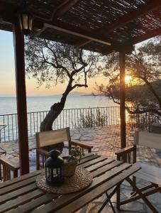 een houten picknicktafel met uitzicht op de oceaan bij Sunset of Pelion in Kato Gatzea