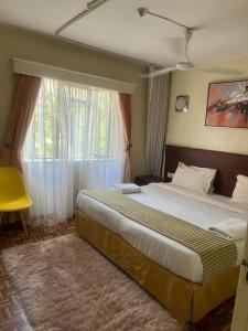 a bedroom with a large bed and a window at Lux Suites Lantana Road Apartments westlands in Nairobi