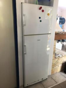 a white refrigerator with magnets on it in a kitchen at Casula Mediterranea in Mali Lošinj