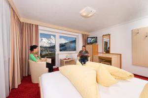 Ein Mann und eine Frau sitzen in einem Hotelzimmer in der Unterkunft Frühstückspension Astoria in Sölden