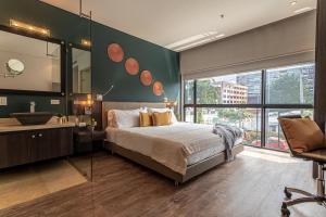 um quarto com uma cama grande e uma janela grande em Soy Local Usaquen em Bogotá