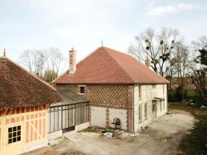 a large house with a red roof and a garage at Studiolo des Sources in Charmont-sous-Barbuise