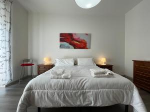 una camera da letto con un letto bianco e asciugamani di MYHOUSE INN MARCHE - Affitti Brevi Italia a Torino