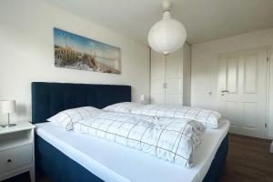 a bedroom with a large bed with a blue headboard at Residenz an der Ostsee in Scharbeutz