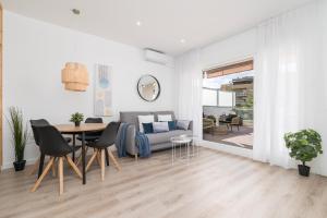 a living room with a table and a couch at Suite Homes Hesperides garden beach in Málaga